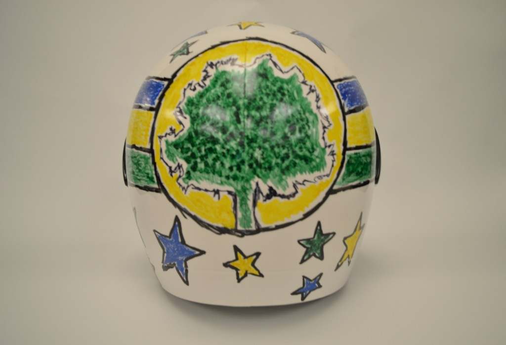 Visão traseira de uma capacete com árvore e estrelas com as cores do Brasil.